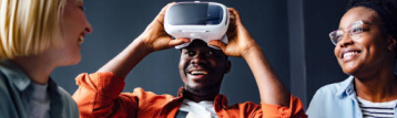 A men doing vr and laughing with a group
